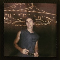 a young man standing in front of a carousel