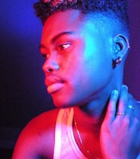 a young man in a tank top with a blue light behind him