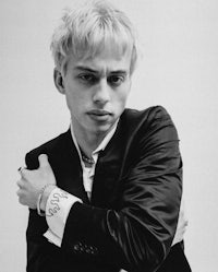 a black and white photo of a young man in a suit