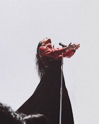 a woman in a red dress is holding a microphone