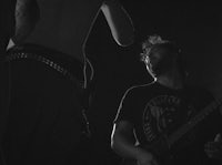 a black and white photo of a man playing a guitar