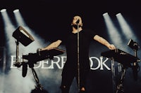 a man standing on a stage with a keyboard in front of him