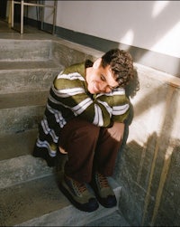 a young man sitting on a set of stairs