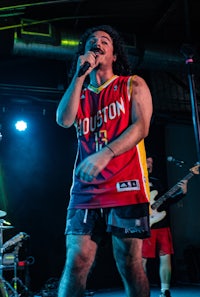 a man in a red jersey singing into a microphone