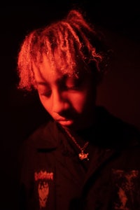 a young man with red hair in a dark room