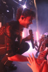 a man holding a microphone in front of a crowd of people