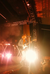 a man playing guitar on stage at a concert