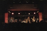 a band performs on stage in a dark room