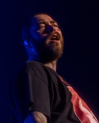 a man with a beard singing into a microphone