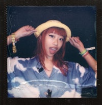 a woman wearing a hat and polaroid camera