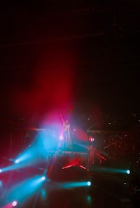 a person standing on a stage with red and blue lights