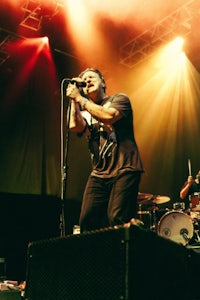 a man is singing on stage at a concert