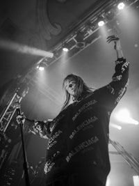 a black and white photo of a woman singing on stage