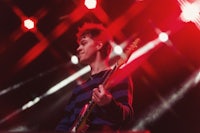 a young man playing a guitar at a concert