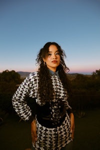 a woman in a black and white houndstooth shirt posing for a photo