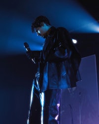 a man in a leather jacket is holding a microphone