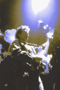 a man playing a guitar in a dark room