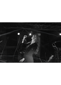 a black and white photo of a woman singing on stage