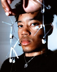 a young man holding up a bunch of wires