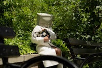 a woman in a white coat sitting on a bench