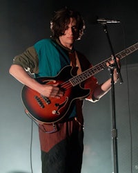 a man playing a bass guitar on stage