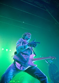 a man playing a guitar on stage