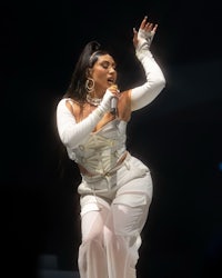 a woman in a white outfit performing on stage