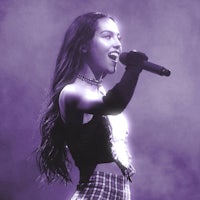 a young woman singing into a microphone