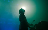 a man in a suit standing in front of a green light