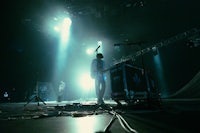 a group of people standing on stage in front of a bright light