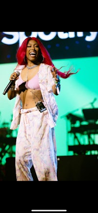 a woman in pink pajamas singing into a microphone