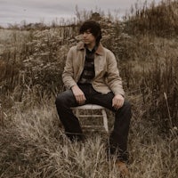 a man sitting on a chair in a field