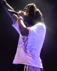 a man with dreadlocks singing into a microphone