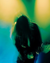 a blurry image of a person playing a guitar