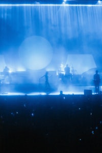 a group of people on stage in front of a blue light