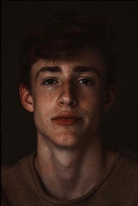 a portrait of a young man with freckles