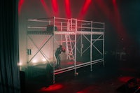 a stage with scaffolding and red lights in the background