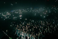 a crowd of people holding up their phones at a concert