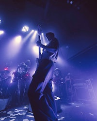 a man standing on stage with a guitar