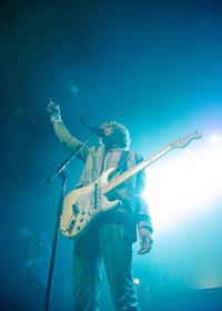 a man playing a guitar on stage