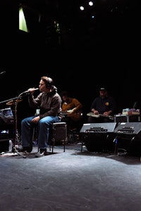 a man is sitting on a stage with a microphone