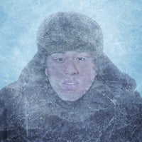 a man wearing a hat and a coat in the snow