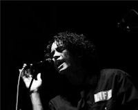 a black and white photo of a man singing into a microphone