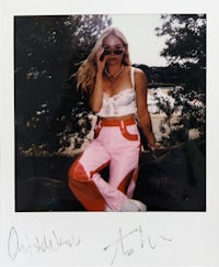 a woman is posing for a photo in pink pants