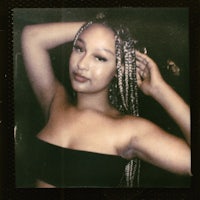 a woman with braids posing for a photo