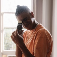 a man holding a camera in front of a window