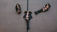 three women laying on the ground in black outfits