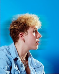 a woman with curly hair and a blue background