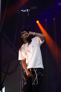 a man with dreadlocks on his head singing into a microphone