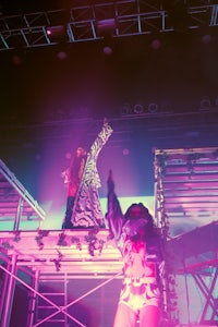 two people standing on a stage in front of colorful lights